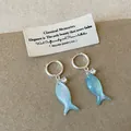 Primo piano dettagliato di orecchini a cerchio con pesce in conchiglia blu e cristalli. - Orecchini Pesciolino (Placcato Oro) / Blu