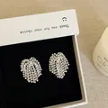 Detailed close-up of sparkling zircon tassel earrings in a minimalist white gift box - Style 27 Earrings