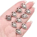 Gedetailleerd macrozicht van zilveren CCB hartjes voor DIY sieraden maken op een handpalm - Hol dubbel hart