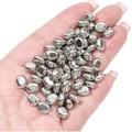 Metallic silver bean-shaped CCB spacer beads for DIY jewelry making held in hand. - Flat Rectangle (BSE045) / 20 Pieces/Pack (7x8mm) / Silver