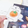 A handmade Halloween pumpkin brooch with glossy enamel finish on a fashion display card - Orange Pumpkin With Green Leaf (A7-126)