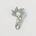 Detaillierte Makroansicht einer silbernen Blumenbrosche mit einer eleganten weißen Perle - Blühender Blumenstil (A1-67)