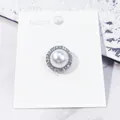Elegante broche voor dames met faux-parel en een rand van sprankelende strass-stenen - Ronde Stijl / Zilver