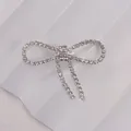 Detailed view of silver bow brooch with sparkling rhinestones and elegant tassels - Simple Bowknot Style (A599) / Silver