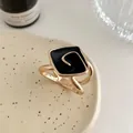 Detail einer goldenen Tuchschließe im koreanischen Stil mit schwarzem Emaille-Spiraldesign - L / Schwarz