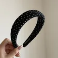 Detail view of a Korean style black fabric wide headband featuring delicate white floral prints - Black Floral Wide Headband