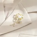 Elegant gold-toned rose brooch with central pearl and crystals on beige suit fabric - Gold Rose (A17-124)