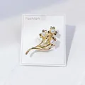 Eleganter goldener Blumenanstecker mit drei Perlen auf einer weißen Mode-Accessoire-Karte - Goldener Blumencluster-Stil (A12-10)