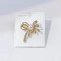 Eleganter goldener Schleifen-Broche mit Perle und Strasssteinen auf weißer Karte - Perlenschleifen-Stil (A12-14)