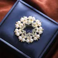 Elegant pearl and rhinestone wreath brooch on a navy blue jewelry gift box display - Round Garland Style (A16-110) / Gold