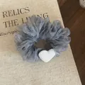Close-up detail of gray ruffled organza scrunchie featuring a soft white heart accent - Dark Blue Striped Scrunchie With Heart