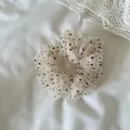 Close-up detail view of a white mesh scrunchie with black polka dots on soft fabric - Small Fine Dot Mesh Scrunchie