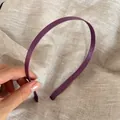 Detailaufnahme eines hochwertigen schmalen lila Satin-Haarreifs vor Leinenhintergrund - Lila