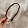 Detalle de diadema de satén marrón sobre fondo de lino que muestra textura de tela - Café