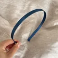 Primer plano de una elegante diadema fina de satén azul marino con textura suave. - Azul