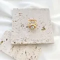 Minimalistischer goldener Seidentuch-Ring mit eleganter Perle auf dekorativem Steinuntergrund - Klein Größe 1