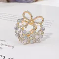 Nahaufnahme eines mit Strass besetzten Kamelienblüten-Schalrings - Kamelie-Schleifen-Kombination (H9)