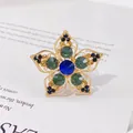 Eleganter Blumenschal-Clip mit blauen und grünen Strasssteinen in glänzender Goldoptik - Dunkelblaue Hauptdiamant Vintage Blume (H10)