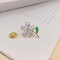 Elegante Brosche mit lila Zirkonblüte, goldenem Stiel und grünem Blattdetail. - Gold Blumen Stil (Lila)