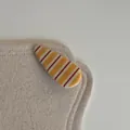Vue détaillée montrant la texture brillante d'une pince à cheveux rayée jaune et rouge - Barrette Goutte d'Eau (6#)
