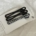 Close-up detail of three elegant black and plaid hair clips on a white display card - Set of 3 / Black Twist Style