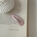 Macro view of a pink gingham fabric covered snap hair clip placed on an open book page - Teardrop Shape (1#) / Pink White Plaid