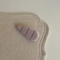 Vue rapprochée d'une pince à cheveux rose minimaliste avec des rayures marron sur un tapis. - Pince à Cheveux Larme (3#)