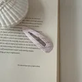 A macro detail shot of a pink striped leather snap clip resting on vintage book paper - Teardrop Style (2#) / Pink White Stripes