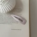 Detailed macro view of pink polka dot leather BB hair clip resting on an open book - Waterdrop (3#) / Pink White Polka Dot