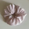 Detailed view of a large light pink scrunchie featuring a colorful speckled fabric texture. - Pink Scrunchie