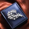 Elegant silver-tone pearl and rhinestone floral brooch on a blue gift box background. - Silver Streamlined Leaf Style (A16-119) / Silver