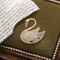 Elegant golden alloy swan brooch adorned with sparkling white crystals for luxury accessories - Single Swan Style (A15-108)