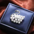 Elegant silver swan-shaped brooch decorated with white pearls on a blue jewelry box - Silver Swan Style (A16-107)