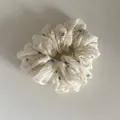 Close-up of off-white scrunchie with blue floral pattern and textured fabric - Style 6 Small Scrunchie / White Camomile
