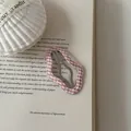 Detailed view of a pink and white gingham checkered wavy hair clip on a vintage book - Cloud Shape (7#)