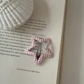 Macro detail of a pink gingham star-shaped hair clip resting on an open vintage book. - Pentagram Shape (10#)