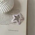 Close-up of a pink star-shaped leather hair clip displayed on an open vintage book - Star Shape (12#)