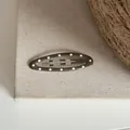 Détail d'une pince à cheveux ovale vert olive à pois blancs sur un fond en toile de lin. - Clip BB Ovale à Pois / Vert Moutarde
