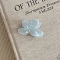 Macro detail of the iridescent acetate flower hair claw with a rhinestone center. - Small Flower Style (12#)