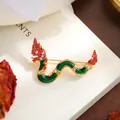 Detailed macro shot of an elegant Chinese dragon brooch with green enamel and crystals - Green Red Gold Dragon Style (A20-21)