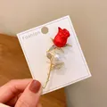 Detail showing elegant red rose brooch with rhinestones and pearl on gold stem - Red Rose Style (A21-90) / Red (A21-90)