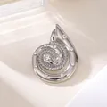 Makroansicht einer eleganten silbernen Spiralbrosche mit funkelnden Strasssteinakzenten - Silber Muschel Spirale Strass Stil (A20-111)