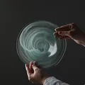 Elegant circular glass fruit plate featuring unique turquoise smoke swirl patterns - Flat Ink Wash / Blue
