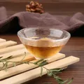 Detailed view of a Japanese style hammered glass tea cup filled with amber tea on wood. - Style 12 (KB001)