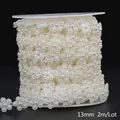 Detailed view of cream white 13mm flower-shaped ABS imitation pearl bead chain on reel - Floral Style / 13mm 2m Pack / Beige