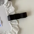 Detailed close-up of an elegant black faux leather bow hair clip on white lace fabric - Large Bow Hair Clip / 2# / Black