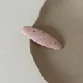Close-up detail of a pink oval hair clip with black polka dots on a beige ceramic plate - Pink Black Polka Dot Oval Hair Clip (5#)