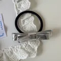 Detail view of a stylish silver metallic leather bow hair tie on a white lace prop - Bow Hair Rope / 5# / Silver