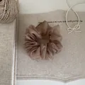 Detailansicht des weichen Organzastoffes und der Faltenstruktur dieses eleganten Haargummis - Kaffeebraun