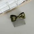 Close-up of elegant olive green satin bow hair comb with metal wire teeth detail. - Green